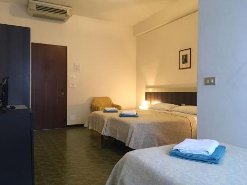a hotel room with two beds with towels on them at Hotel Centrale in Este