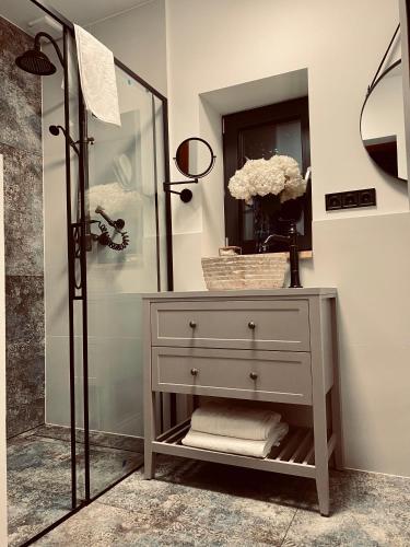 a bathroom with a white dresser and a shower at Marzeniówka in Lutowiska