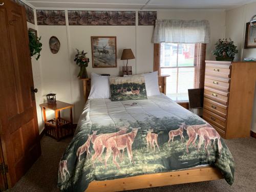 a bedroom with a bed with a painting of deer at carrollmotel and cottages in Twin Mountain