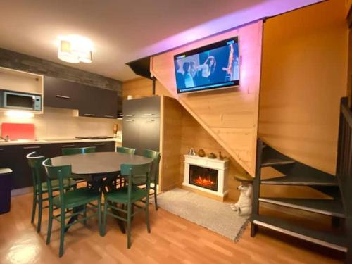 a kitchen and dining room with a table and a fireplace at Duplex rénové - 3 CHAMBRES 8 PERS dernier étage in Les Orres
