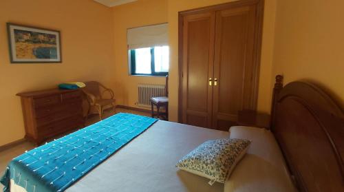 een slaapkamer met een bed met een blauwe deken erop bij Apartamento Samil Primera Línea de Playa 2M in Vigo