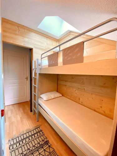 Ce lit superposé se trouve dans un dortoir doté d'une lucarne. dans l'établissement Duplex rénové - 3 CHAMBRES 8 PERS dernier étage, aux Orres