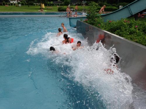 a group of children are riding a water slide in a pool at Hanserhof in Zell am Ziller