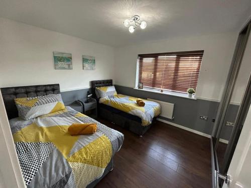 een slaapkamer met 2 bedden en een raam bij Sensational 3-Bed Home Near Bluewater in Kent