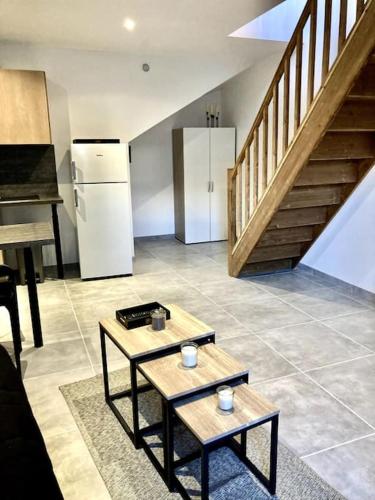 d'une cuisine avec deux tables et un réfrigérateur et des escaliers. dans l'établissement Duplex au coeur du village, à Les Mées