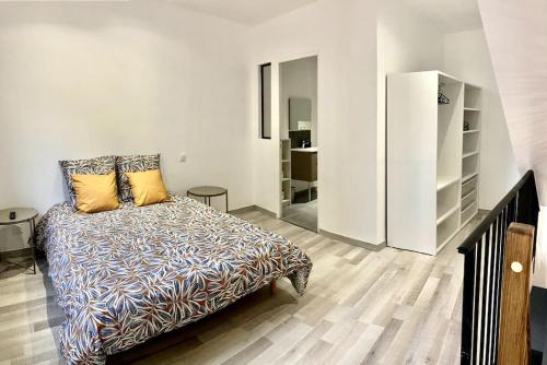 een slaapkamer met een bed en een witte koelkast bij Duplex au coeur du village in Les Mées