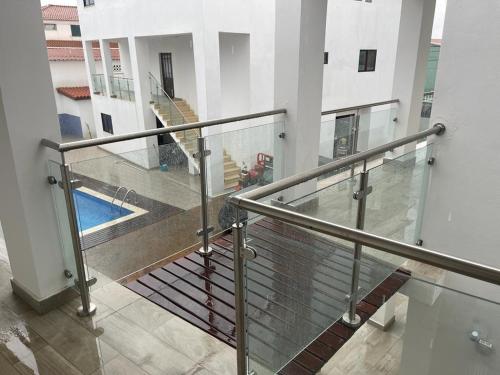 a balcony with a metal railing and a swimming pool at Hotel Kenito in São Tomé