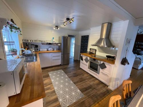 cocina grande con electrodomésticos blancos y suelo de madera en Charmig stuga med panoramautsikt över sjön Siljan. en Rättvik