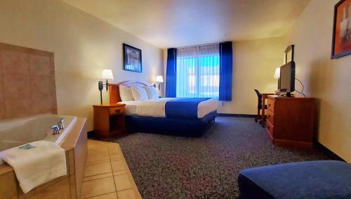 マニトゥー・スプリングスにあるMagnuson Grand Pikes Peakのベッドルーム(ベッド1台、バスタブ付)が備わる客室です。