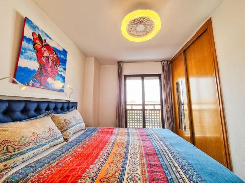 een slaapkamer met een bed met een schilderij aan de muur bij Piso ideal con WIFI Parking y Desayuno in Murcia