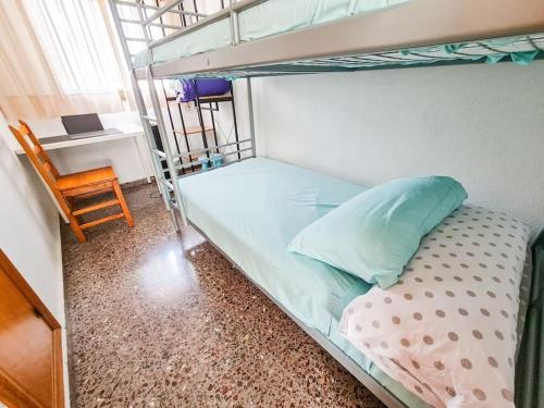 a bedroom with a bunk bed and a chair at Piso ideal con WIFI Parking y Desayuno in Murcia