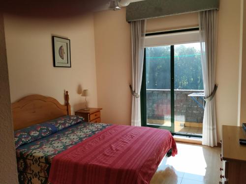 1 dormitorio con cama y ventana grande en Apartamento Samil Primera Línea de Playa 3O, en Vigo