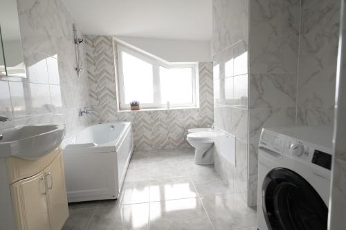 bagno bianco con lavandino e lavatrice di Bright and cozy apartment nr. 5 a Chişinău