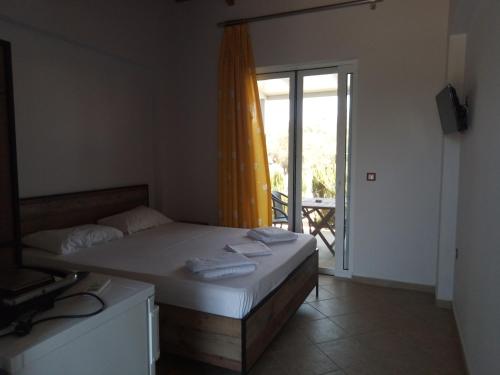 a bedroom with a bed and a door to a patio at Rock Rooms in Lefkada