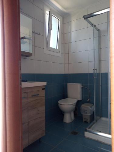 a bathroom with a toilet and a sink and a shower at Rock Rooms in Lefkada