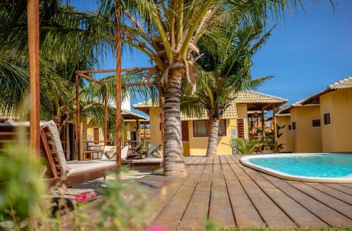 a resort with a swimming pool and palm trees at Beekite Wind Village in Luis Correia