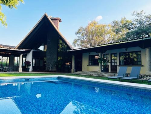 a swimming pool in front of a house at Villa Tatala hotel boutique in Tepoztlán