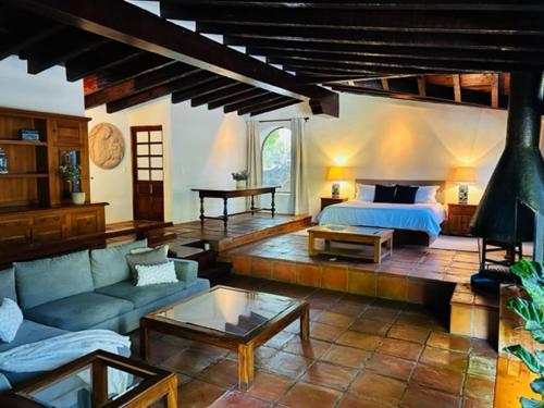 een woonkamer met een bed en een bank bij Villa Tatala hotel boutique in Tepoztlán