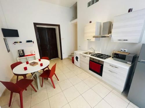 eine Küche mit einem Tisch und roten Stühlen in der Unterkunft Napoli Forcella House al centro di Napoli in Neapel