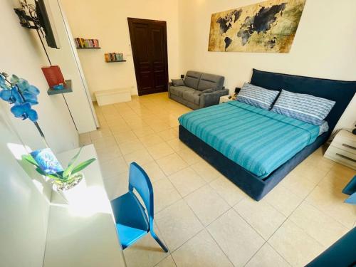 ein Schlafzimmer mit einem Bett, einem Sofa und einem Stuhl in der Unterkunft Napoli Forcella House al centro di Napoli in Neapel