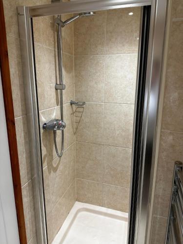 a shower with a glass door and a shower at The King Alfred in Street