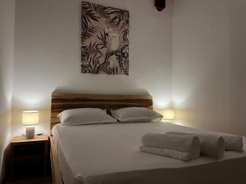 a bedroom with a large white bed with two lamps at Villa Timoun - Standing - 3 ch in Quartiers Anse à lʼÂne