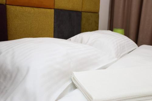 2 camas blancas con almohadas blancas en un dormitorio en Apartman Maksim Ravna Planina en Pale