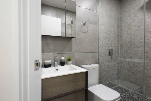 y baño con lavabo, aseo y ducha. en 75-1A NEW Prime UES W D in unit Elevator, en Nueva York