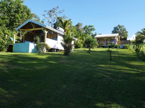 a house in a field with a large yard at La Joupa case Anthurium in Sainte-Rose
