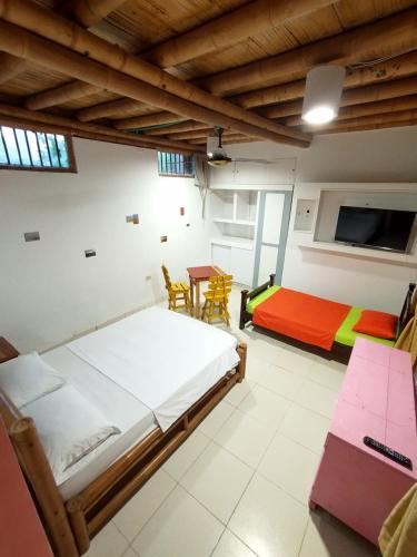 1 dormitorio con 1 cama, mesa y sillas en Casa MITA Taganga en Taganga