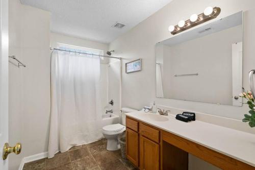 a bathroom with a sink and a toilet and a mirror at Cozy 4B 2 5B University Home King Beds Jacuzzi in Charlotte