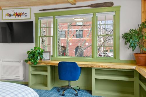 a green home office with a window and a blue chair at Downtown Camden Hotel in Camden