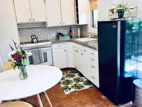 a kitchen with a white table and a blue refrigerator at 2-Bedroom Suite in the Heart of Downtown in Weyburn