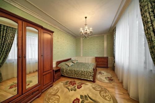 a bedroom with a bed and a chandelier at Hotel&Restaurant SENATOR in Truskavets