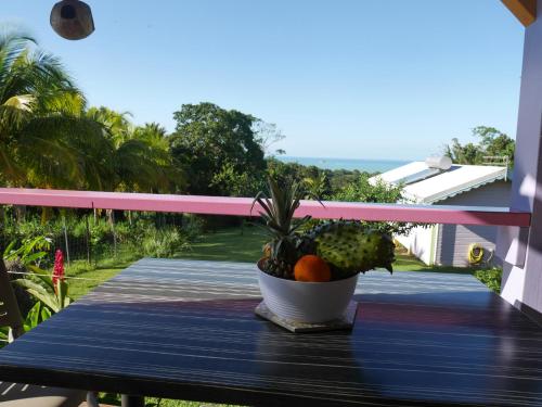 a bowl of fruit on a table on a balcony at La Joupa case Anthurium in Sainte-Rose