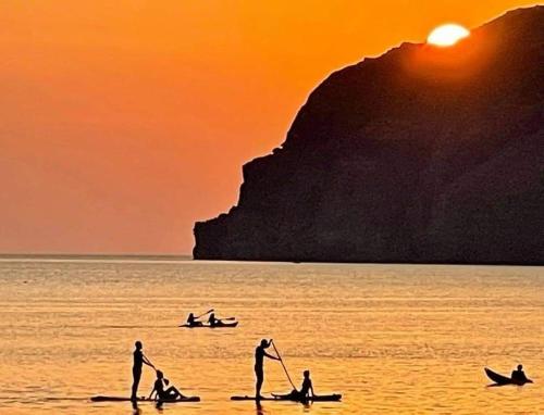 a group of people in the water at sunset at Marilena in Skala Eresou