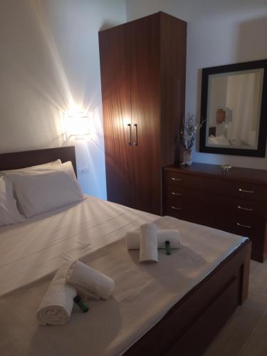 a bedroom with a bed with towels and a dresser at Enigma Boutique Houses Ammos in Marmarion