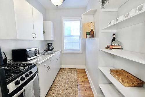 a white kitchen with a stove and a sink at Global Cup Relaxing 1 BR near Lower Greenville Free Parking in Dallas
