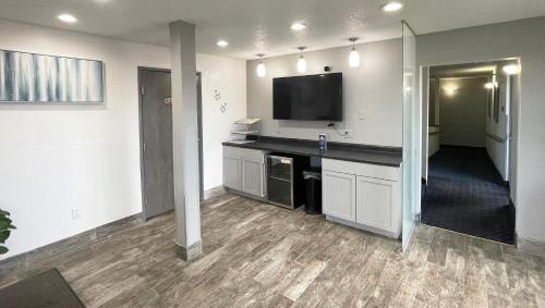 a living room with a flat screen tv on a wall at Magnuson Hotel Fort Wayne North - Coliseum in Fort Wayne