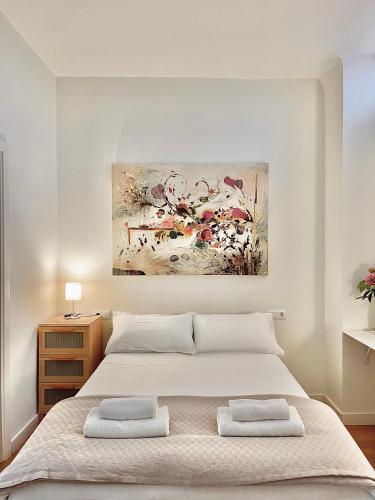 a bedroom with a bed with two towels on it at El Apartamento de Trini en la Alameda in Seville