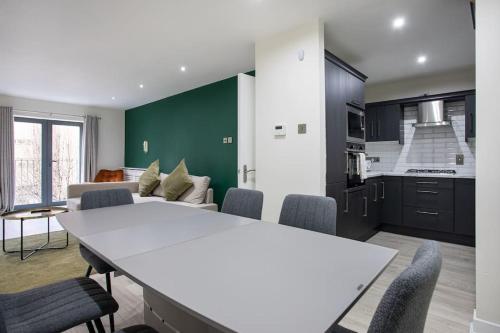 a kitchen and living room with a white table and chairs at Luxury, Sleeps 6, City Centre in Belfast