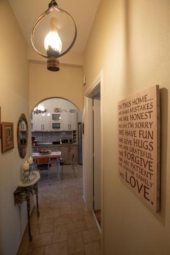 a hallway with a sign on the wall of a kitchen at Ruby's summer house with spacious garden and free parking in Gavrion