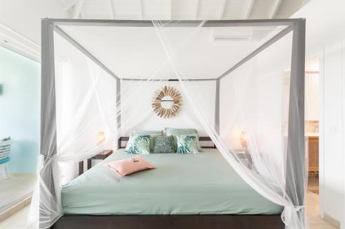 a bed with a canopy in a room at Mon Paradis Bleu beach house, 2 bedrooms and sea view! in Saint Martin