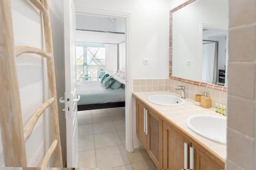 een badkamer met 2 wastafels, een spiegel en een bed bij Mon Paradis Bleu beach house, 2 bedrooms and sea view! in Saint Martin