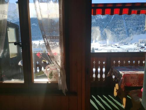 ein Fenster mit Blick auf einen schneebedeckten Berg in der Unterkunft Studio avec vue splendide sur les Diablerets in Les Diablerets