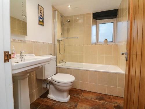 een badkamer met een toilet, een wastafel en een bad bij Potters Cottage in Lynton