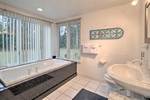 a bathroom with a tub and a toilet and a sink at Riverfront Savannah Getaway with Pool and Dock! in Savannah