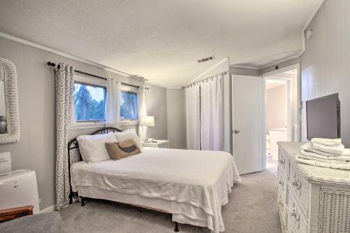 a white bedroom with a bed and a window at Riverfront Savannah Getaway with Pool and Dock! in Savannah