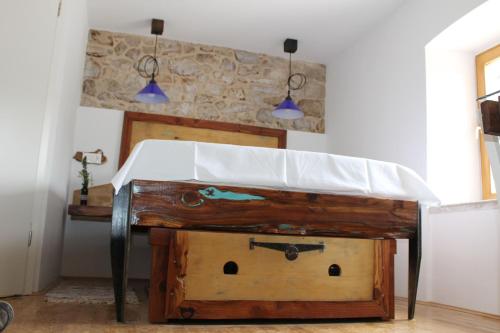 a wooden table in a room with two lights at Apartmani Pelješac Sova in Sreser