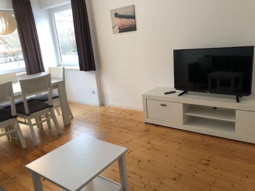 a living room with a flat screen tv and a table at Ferienhaus-Wiesenblick in Gammendorf